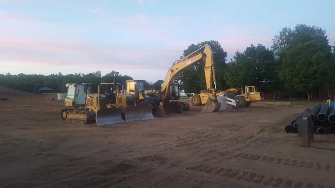 The Advanced Excavating fleet — dozers, excavators, and loaders — staged at dawn