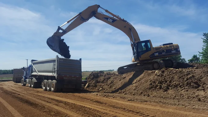Cat 330C excavator loading a dump truck from a dirt stockpile
