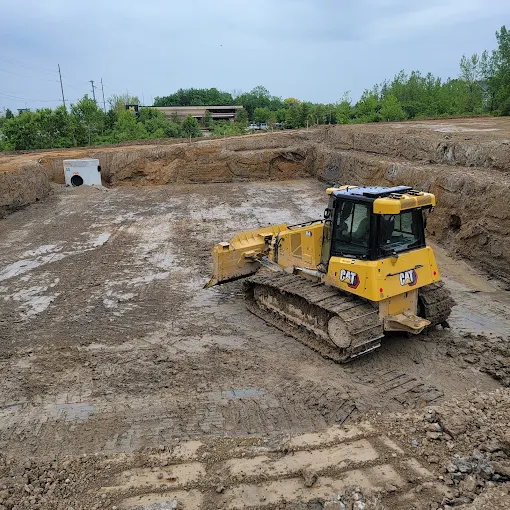 Excavators and wheel loaders staged on a freshly cleared building pad