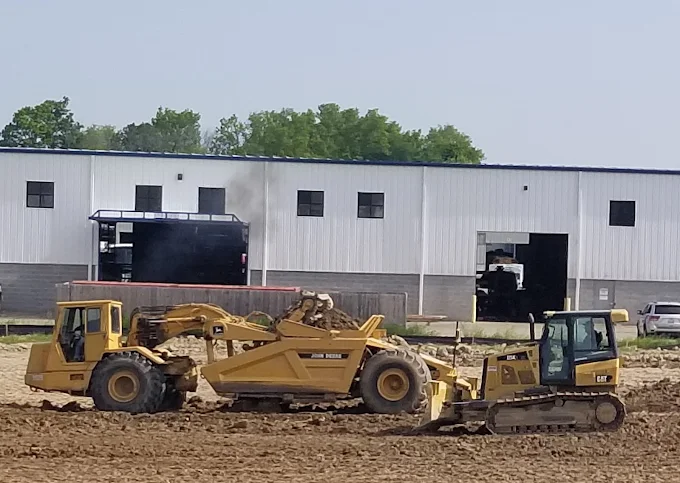 A lineup of Cat excavators and wheel loaders staged on a jobsite