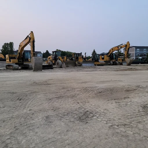 Excavator fleet staged on a large commercial dirt pad